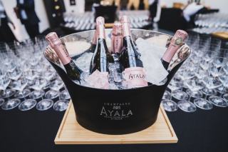 Bouteille de vin dans un seau d'eau glacée à côté de verres sur une table